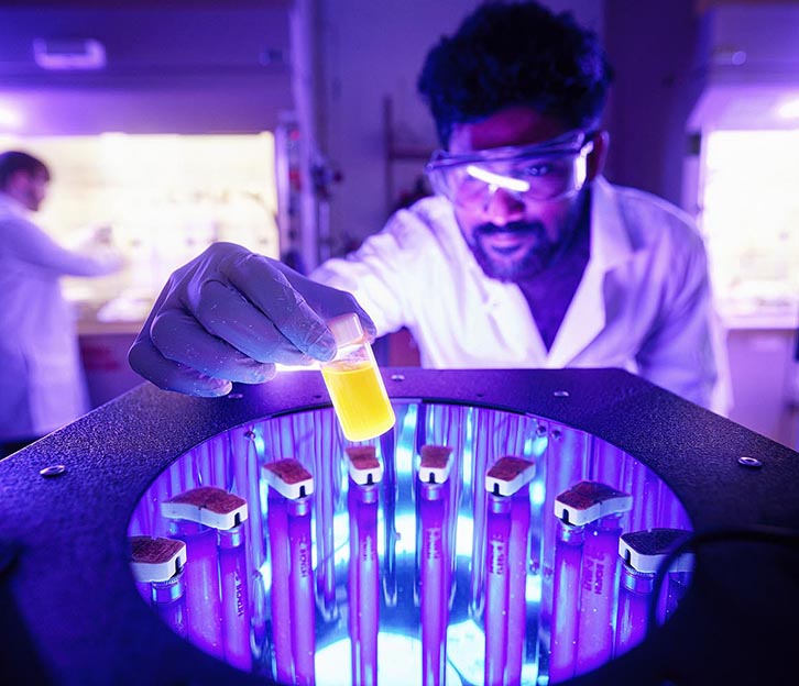 Lighted effects of a researcher looking at samples in a centrifuge.